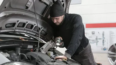 Человек под капотом автомобиля
