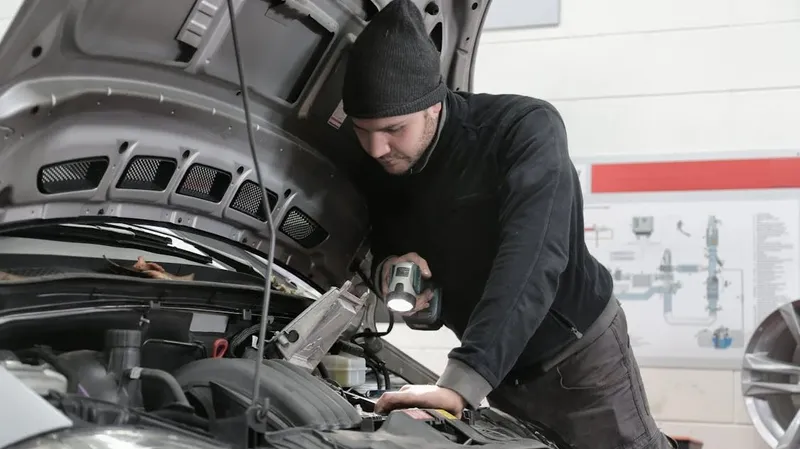 Человек под капотом автомобиля
