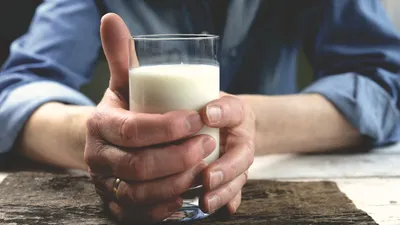 Стакан с молоком в руках человека